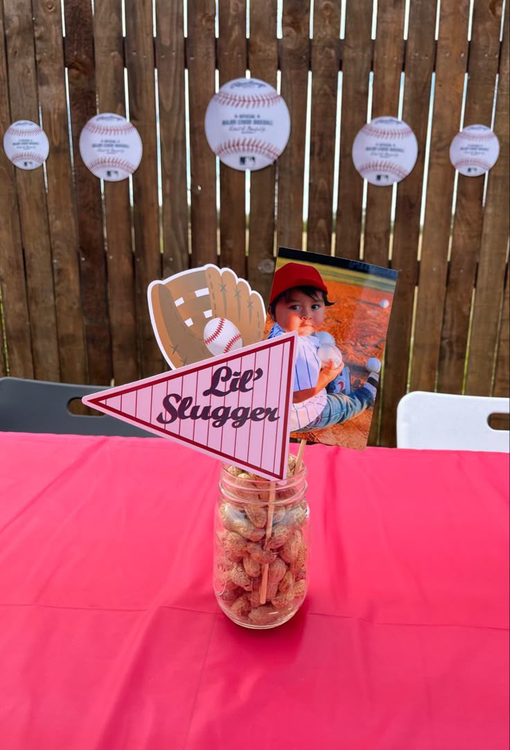 a jar filled with candy sitting on top of a pink table cloth covered tablecloth