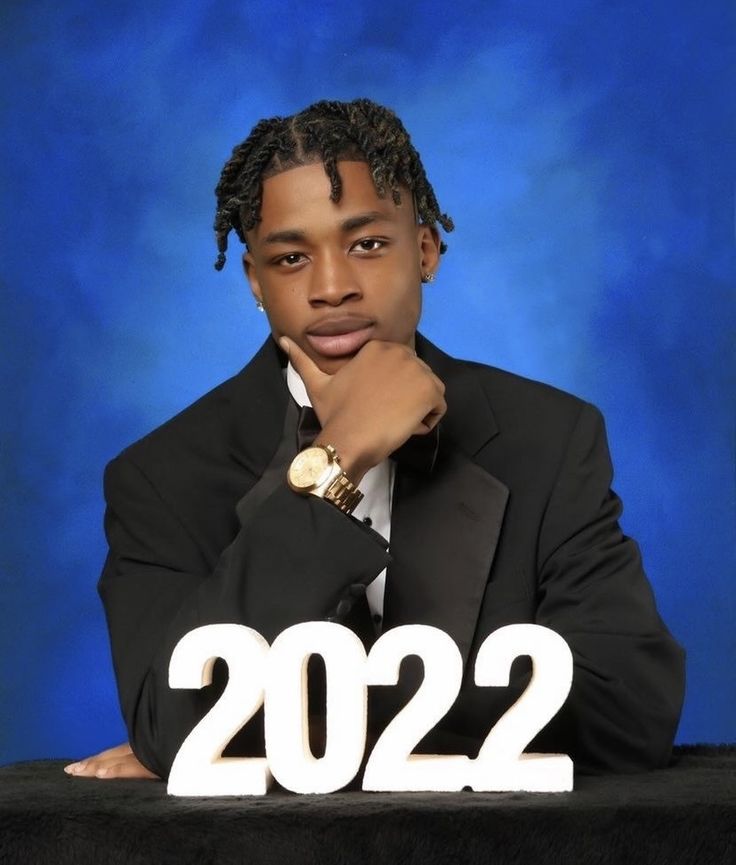 a man in a suit and tie sitting at a table with the number 2012 written on it