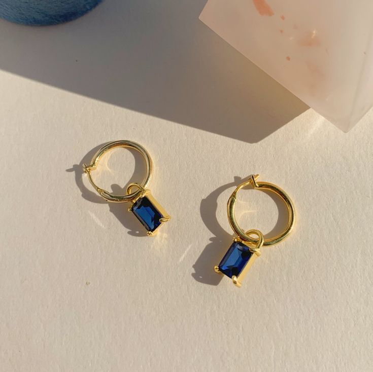 Inspired by the colors of the sky at dawn, a blue sapphire glows on a sun-kissed gold hoop. Sapphire is also known as September birthstones. These sapphire baguette charms are interchangeable, add our sapphire charms to huggies or your favorite pair of hoops to show how much you love September babies.  D E T A I L S - Materials: 14k gold over sterling silver. They are 14k gold THICK plated, and they can last for a very long time with proper care. - Stone: 4mm x 6mm natural sapphire stones; Charm September Baby, Sapphire Stones, Dangle Hoop Earrings, September Birthstone, Sapphire Stone, Natural Sapphire, Jewelry Boxes, Sun Kissed, Gold Hoop