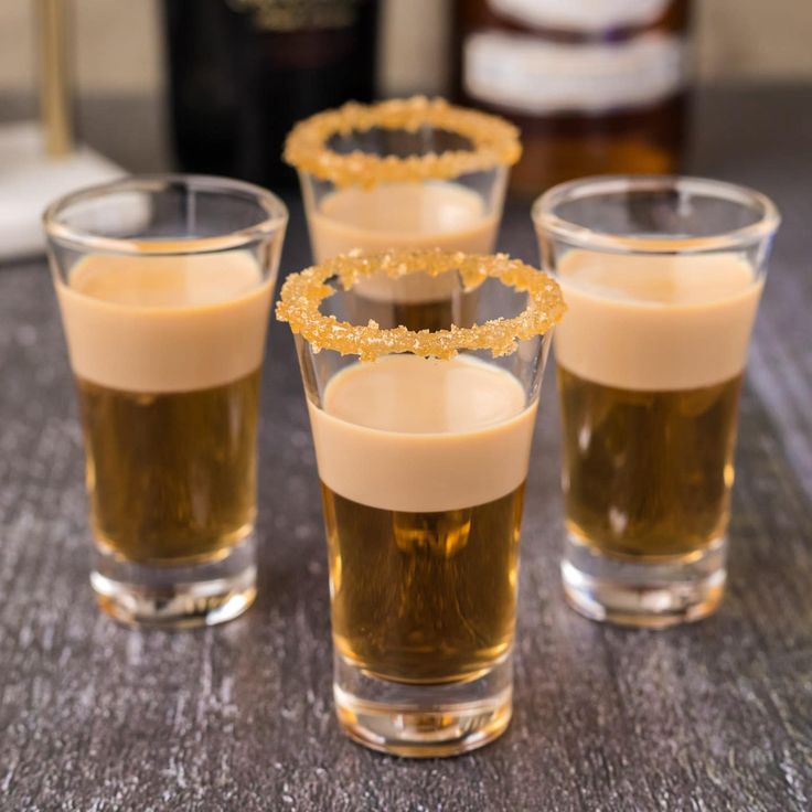 three glasses filled with liquid sitting on top of a table