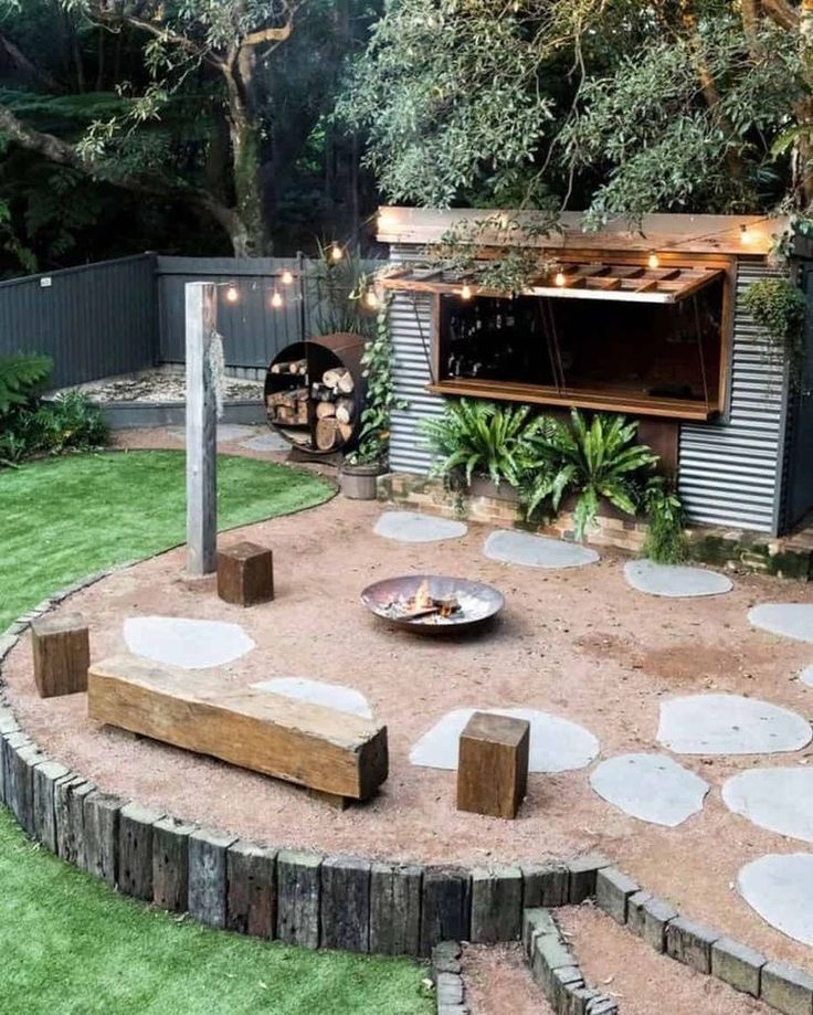 an outdoor kitchen is built into the side of a backyard with grass and stepping stones