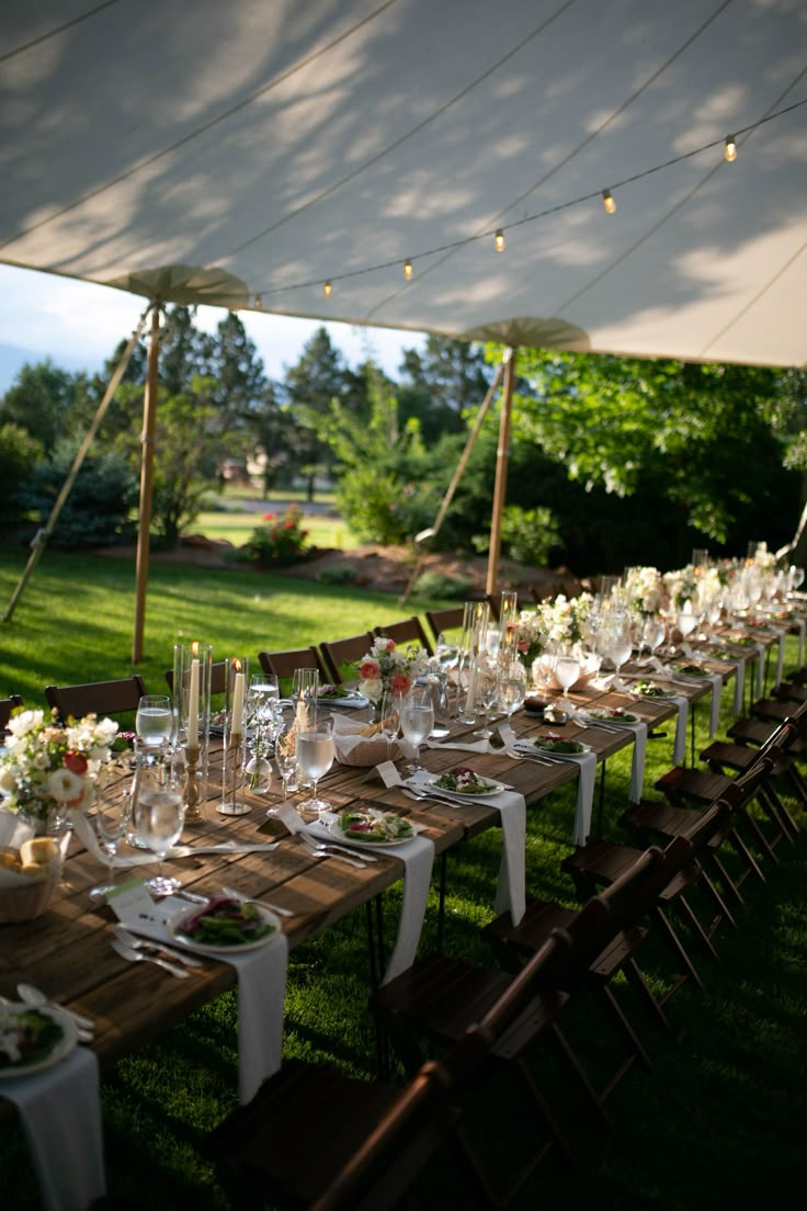 a long table is set up for an outdoor dinner