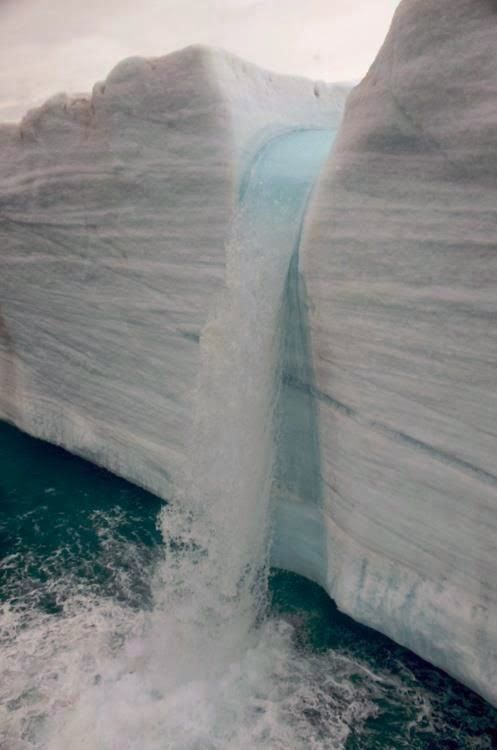 an iceberg that has been partially submerged in the water with waves coming out of it