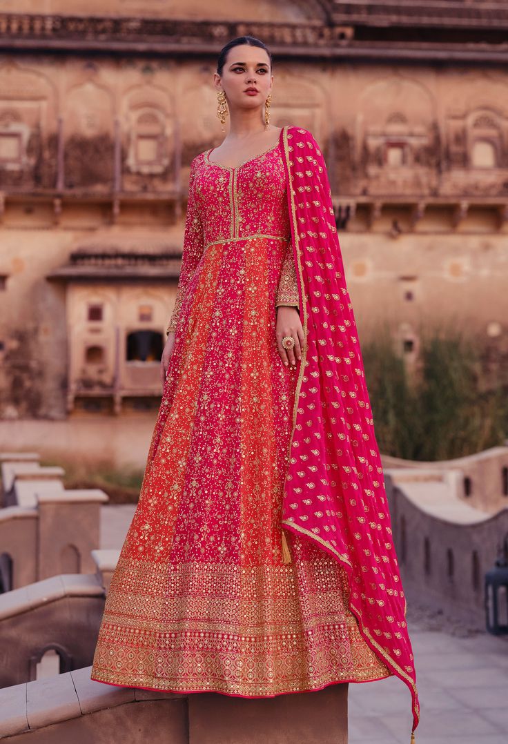 COLOR : Orange & Pink FABRIC : Gown & Dupatta - Premium Georgette WORK : Heavy Zari Work, Hand Work, Motifs, Stones, Pearls, Swarvoski, Sequins, Embellished Lace Border OCCASION : Wedding, Reception, Engagement, Bridal Wear READY-TO-WEAR : NoSTITCHING : Available as semi-stitched fabric, can be stitched using standard size option (+$30). Note: There might be a slight color variation due to lighting and flash used during photoshoot. The bright shade seen is the best closer view of fabric's color. Bridal Anarkali Suits Engagement, Orange Anarkali Suits, Heavy Anarkali Suits Wedding, Heavy Anarkali Dress, Pink And Orange Lehenga, Baat Pakki, Bridal Anarkali, Heavy Lehenga, Georgette Anarkali