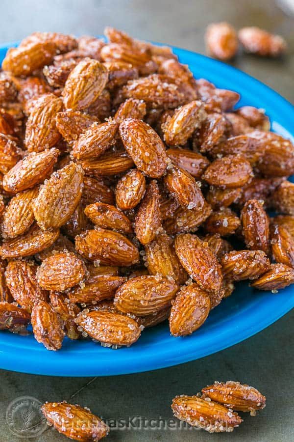 a blue plate filled with almonds on top of a table