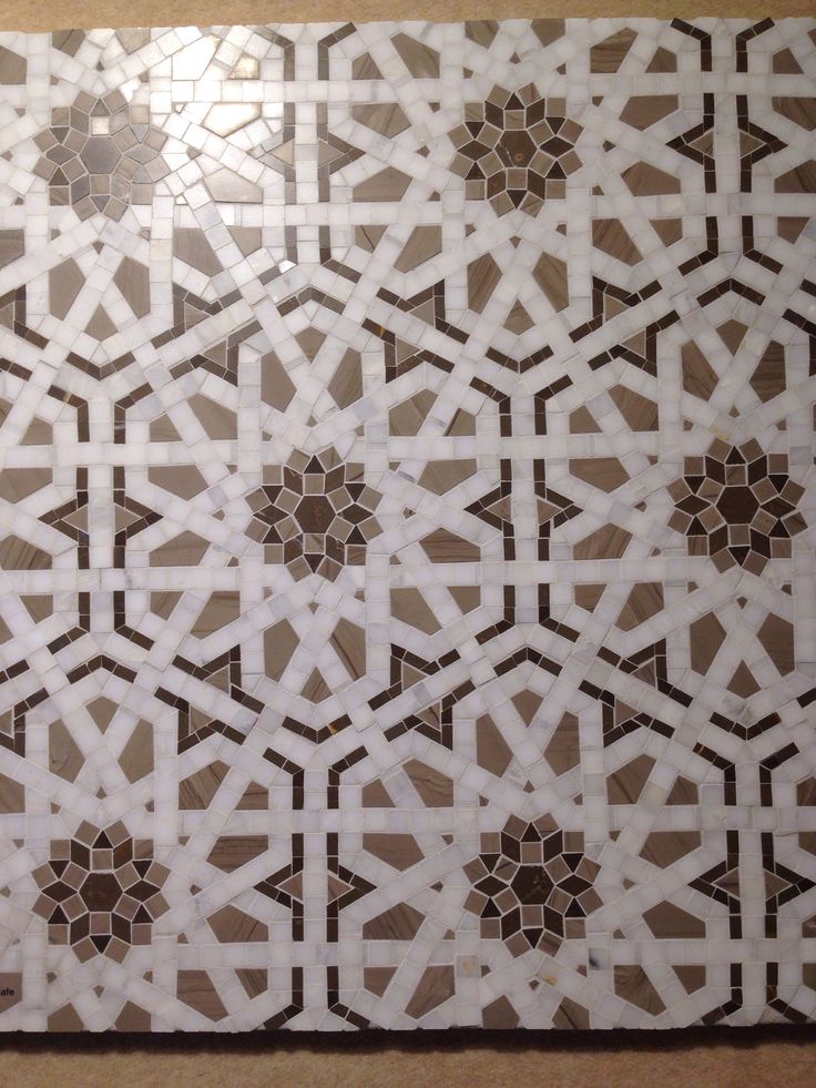 an intricately designed tile pattern in brown and white