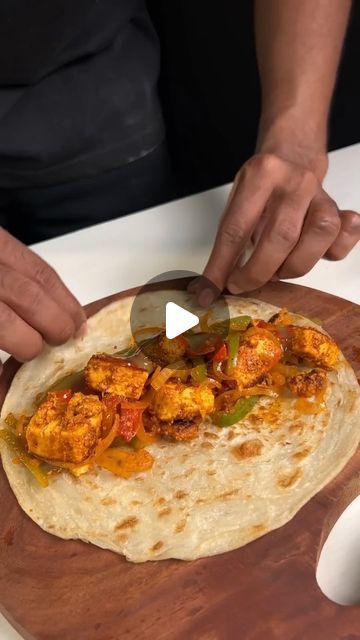 a person cutting up food on top of a wooden board