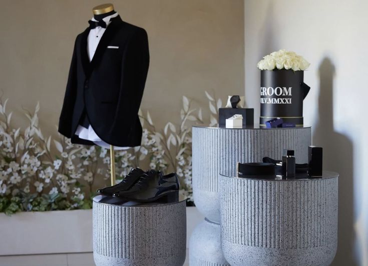 a suit and shoes are on display in front of a mannequin