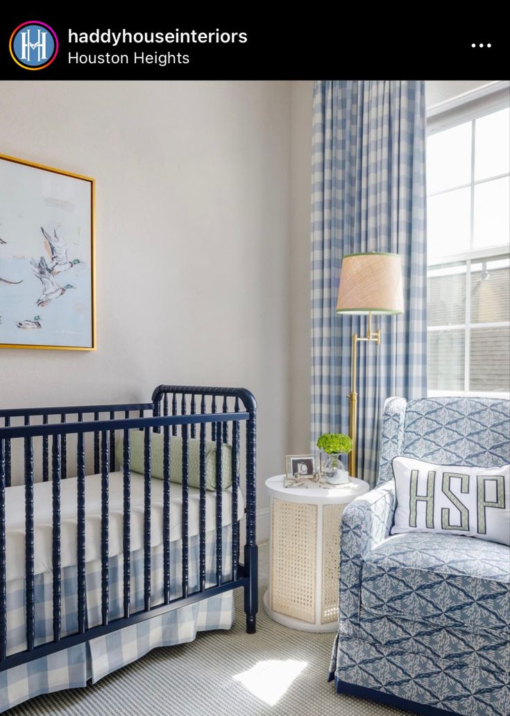 a baby's room with a blue and white chair, crib, and window