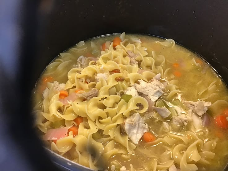 a pot filled with pasta and chicken soup