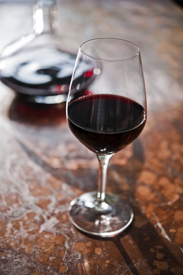 two glasses of wine sitting on top of a wooden table next to eachother