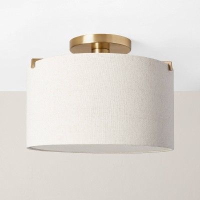 a light fixture hanging from the ceiling with a white shade on it's side