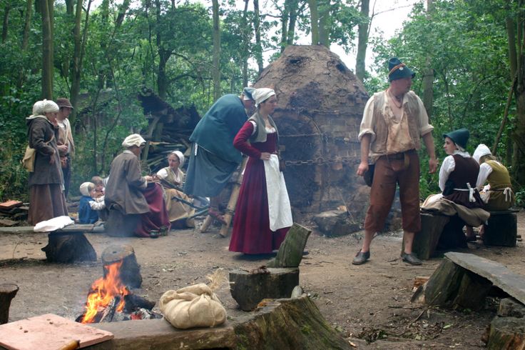 people are gathered around a campfire in the woods