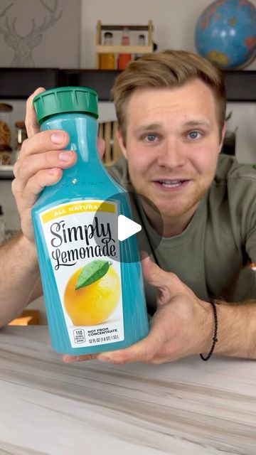 a man holding up a bottle of simply lemonade