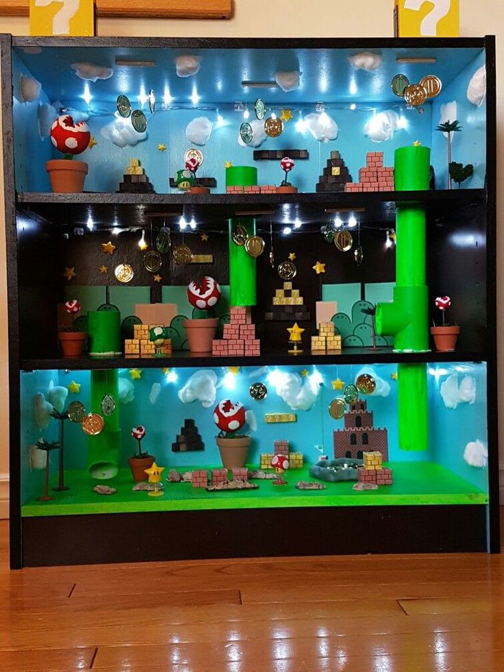 a display case with mario's world on the top and other items in it