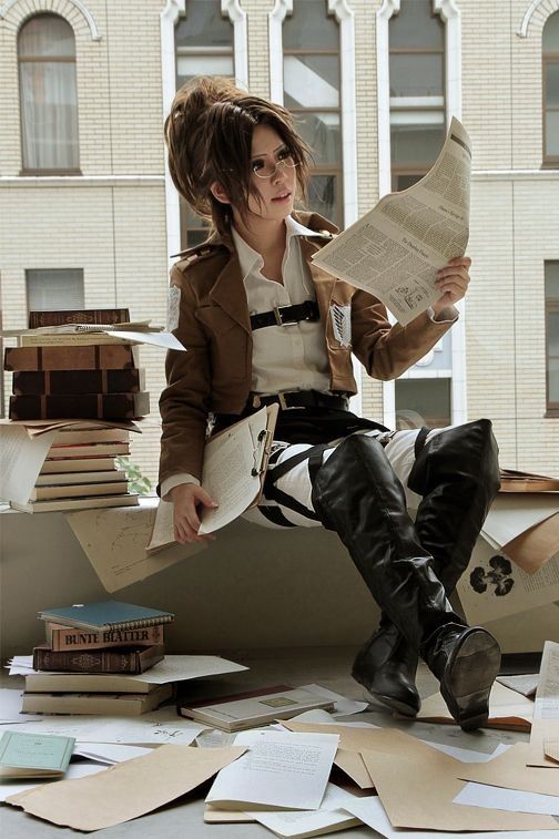 a woman sitting on top of a pile of books while holding a newspaper in her hand