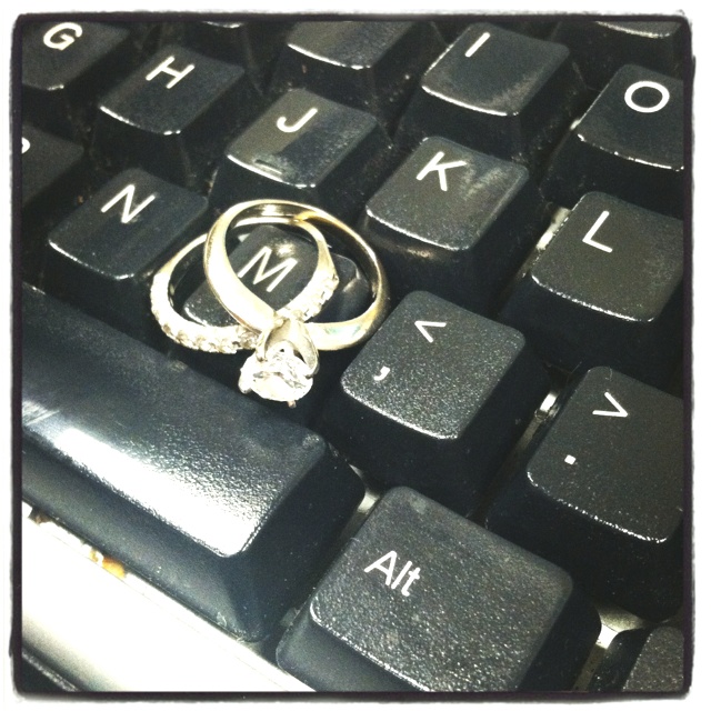 two wedding rings sitting on top of a computer keyboard