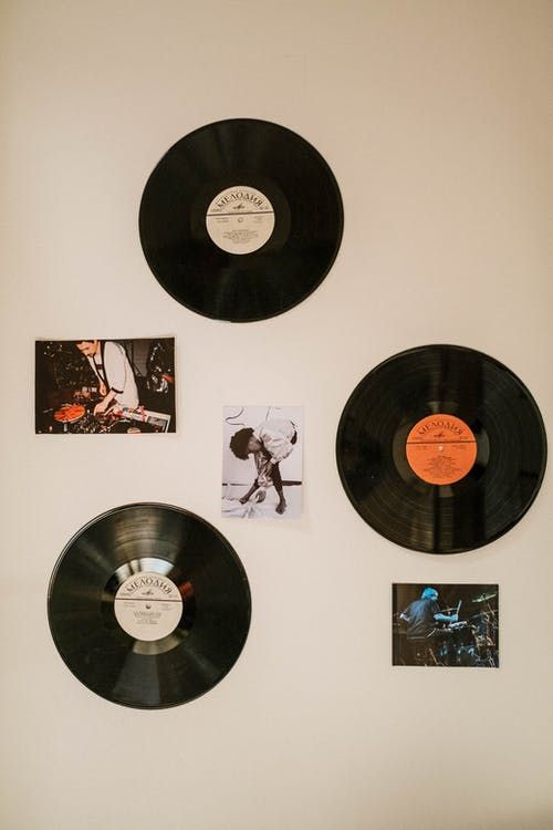 three black vinyl records are hanging on the wall