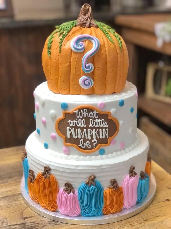 a three tiered cake decorated with pumpkins and the number one on top is question mark