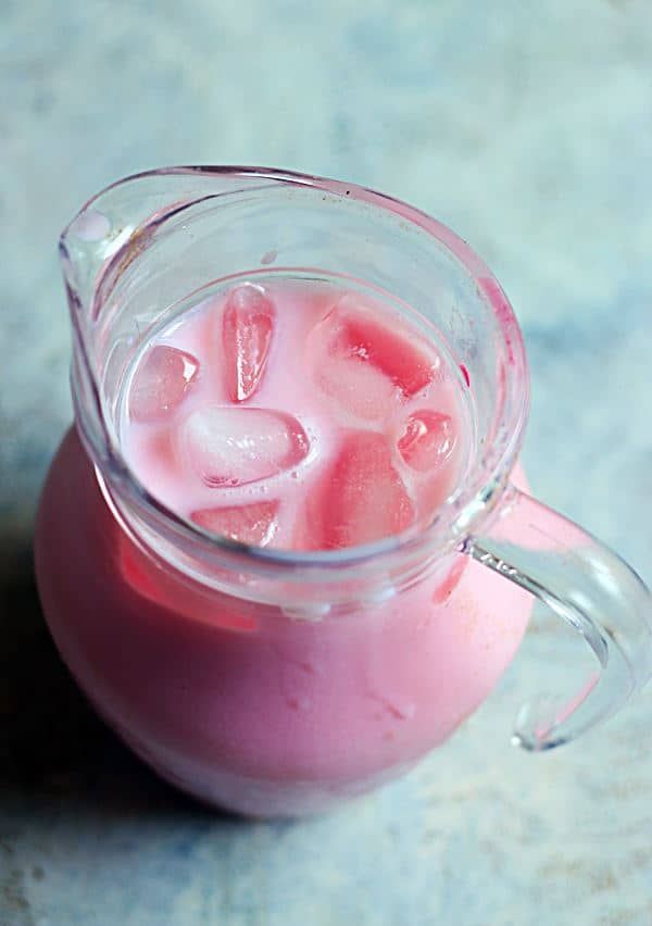 a pitcher filled with ice sitting on top of a table