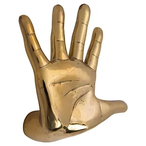 a gold hand that is holding something in it's palm and has two fingers extended out