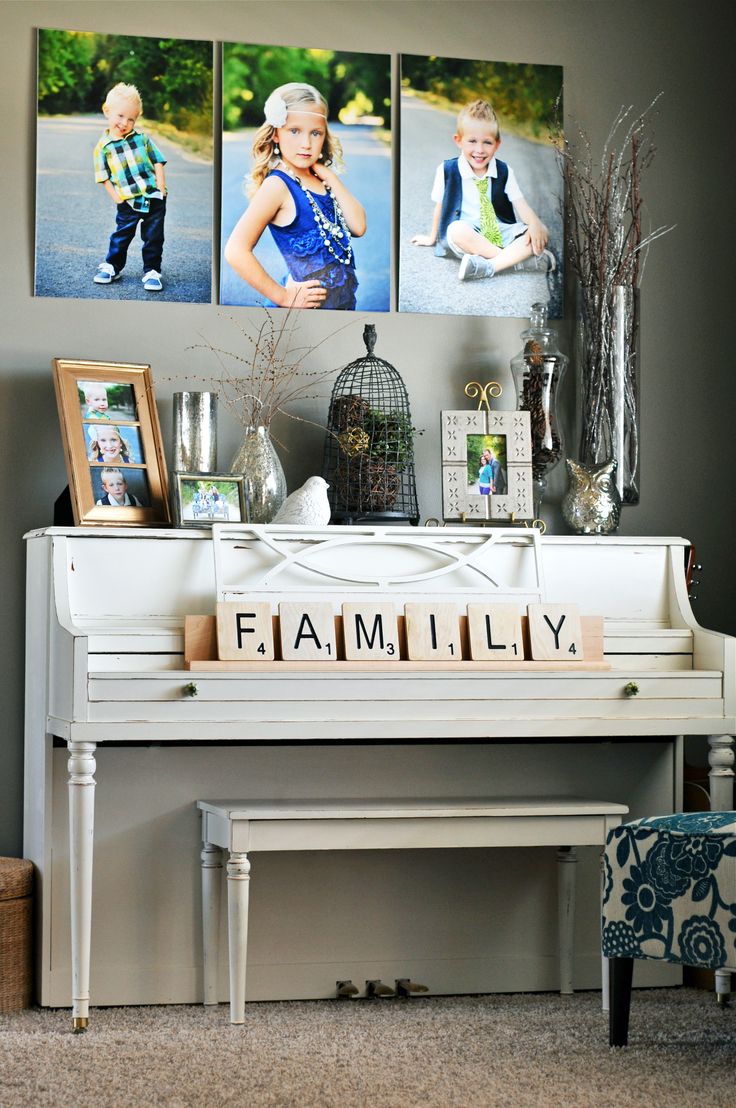 a white piano sitting in front of three pictures