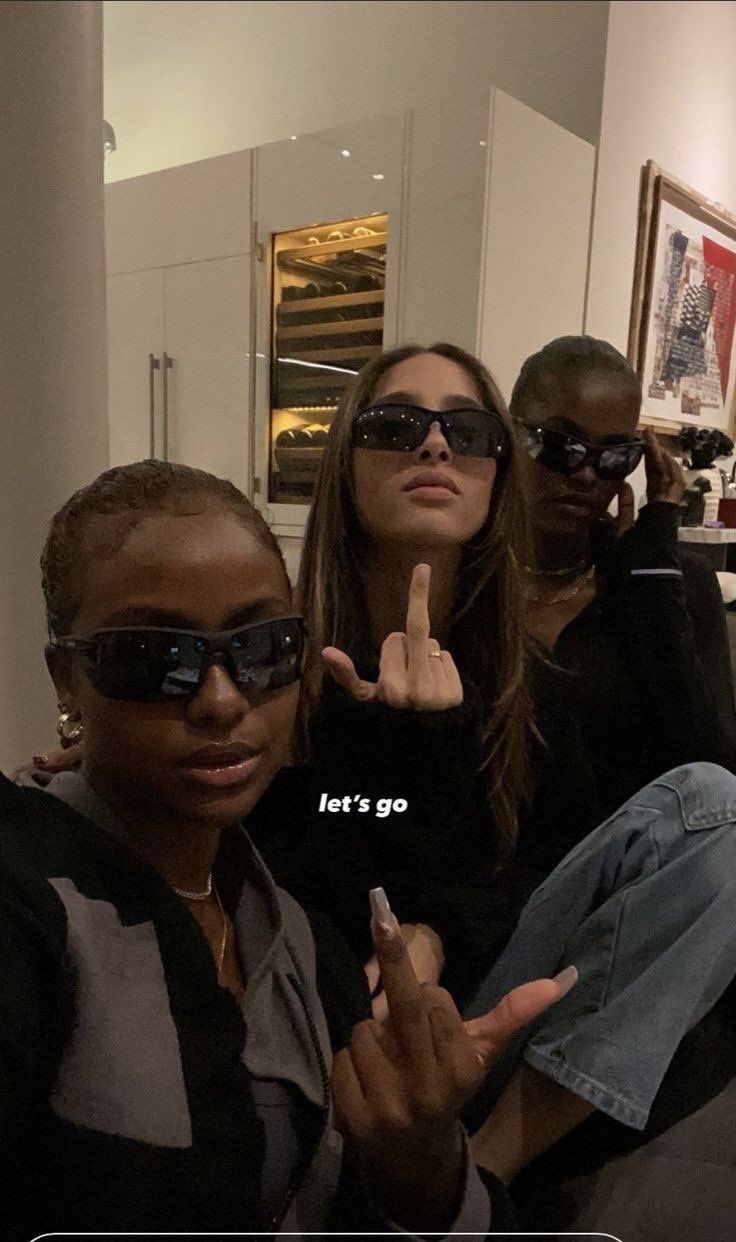 three women in sunglasses posing for the camera