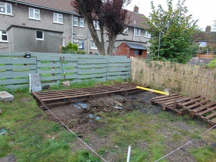 an empty backyard with wooden slats in the middle and grass growing on the ground