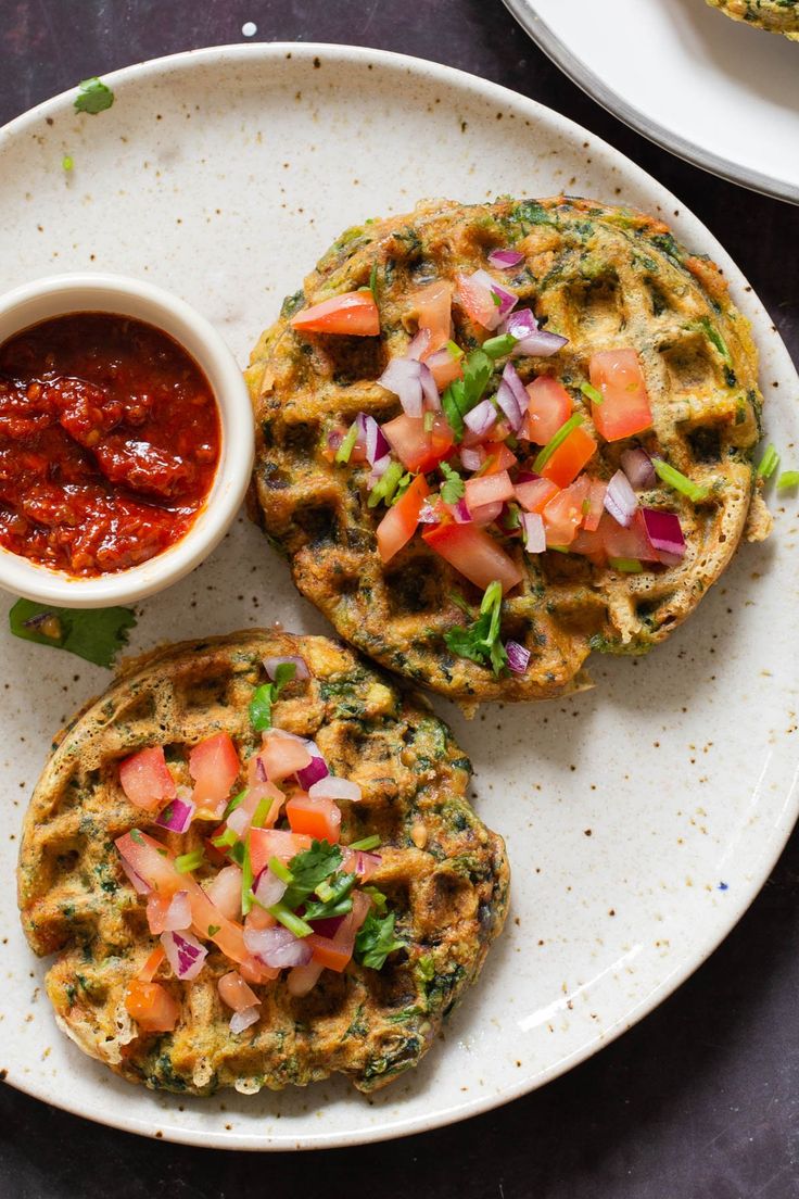 two waffles on a plate with salsa and ketchup