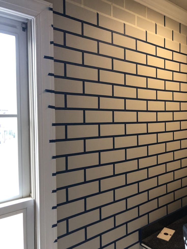 a white brick wall next to a window in a room with blue trim on it