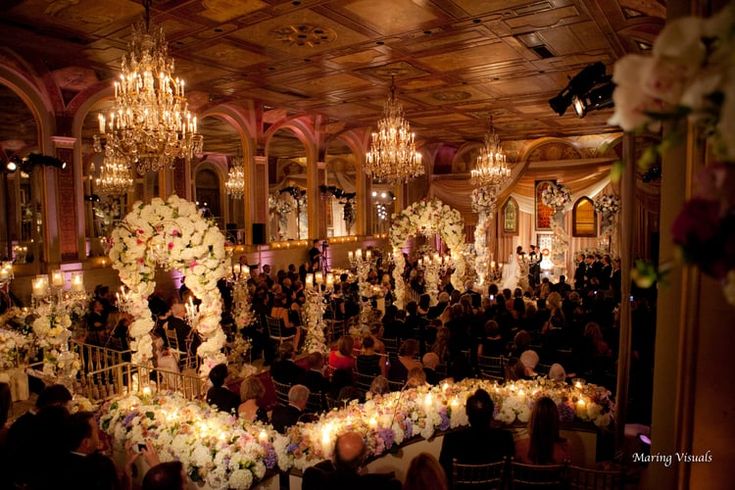 a large room filled with lots of people and chandeliers hanging from the ceiling