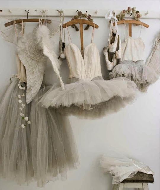 there are several dresses hanging on the clothes rack in this room, and one is wearing a tutu skirt