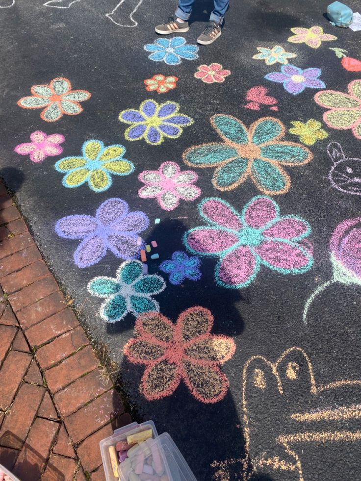 the sidewalk is decorated with chalk and crochet flowers, which are drawn in different colors