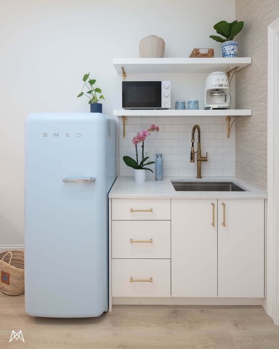 a blue refrigerator freezer sitting inside of a kitchen next to a white counter top