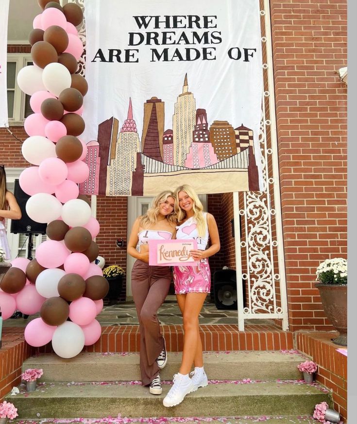 two women standing next to each other in front of a sign that says, where dreams are made of