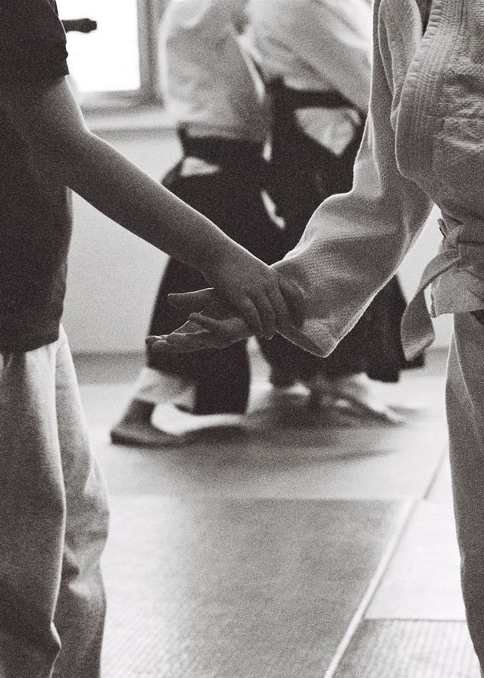 black and white photograph of two people holding hands