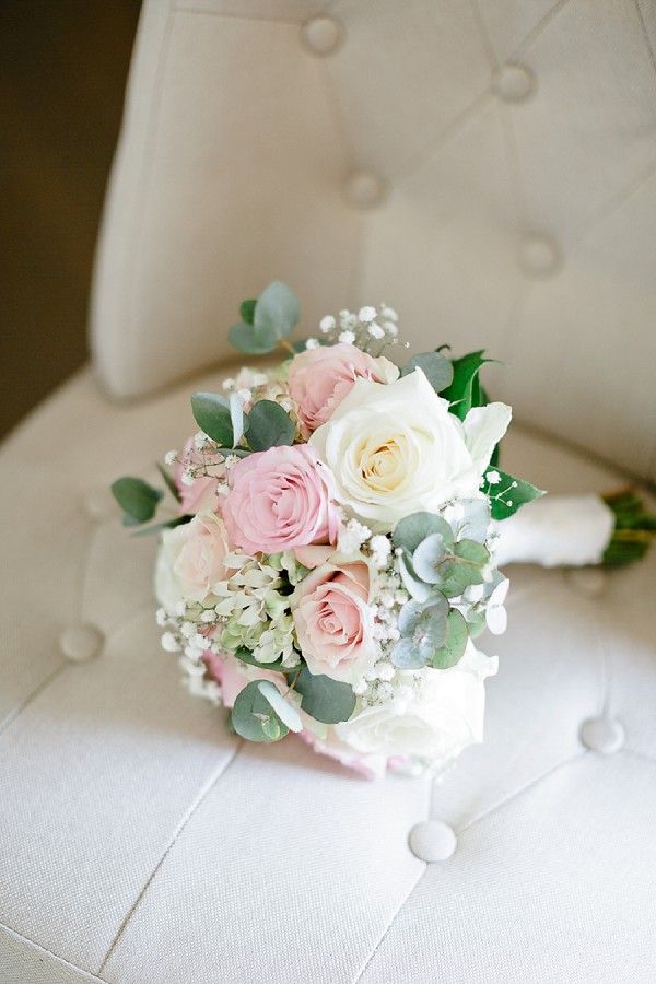 a bridal bouquet sitting on top of a white chair