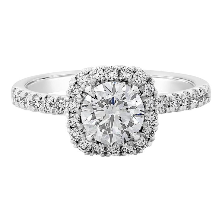 a white gold engagement ring with diamonds on the band and an oval center stone surrounded by round