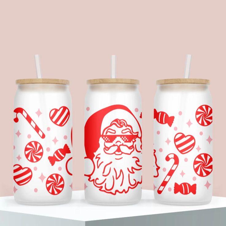 three red and white cans with santa's face, candy canes and lollipops on them