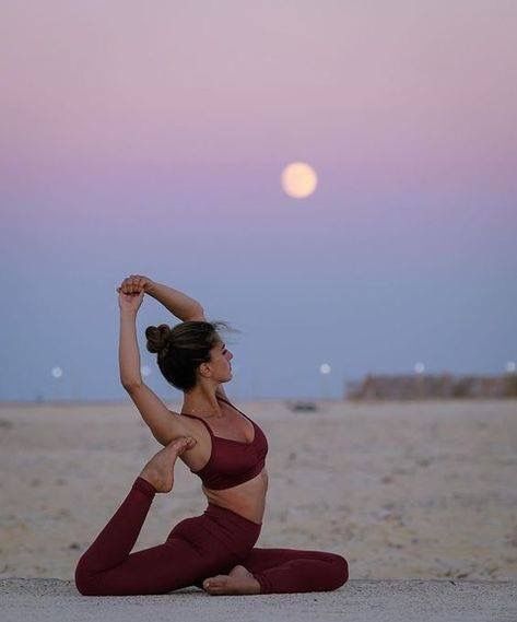 a woman is doing yoga on the beach