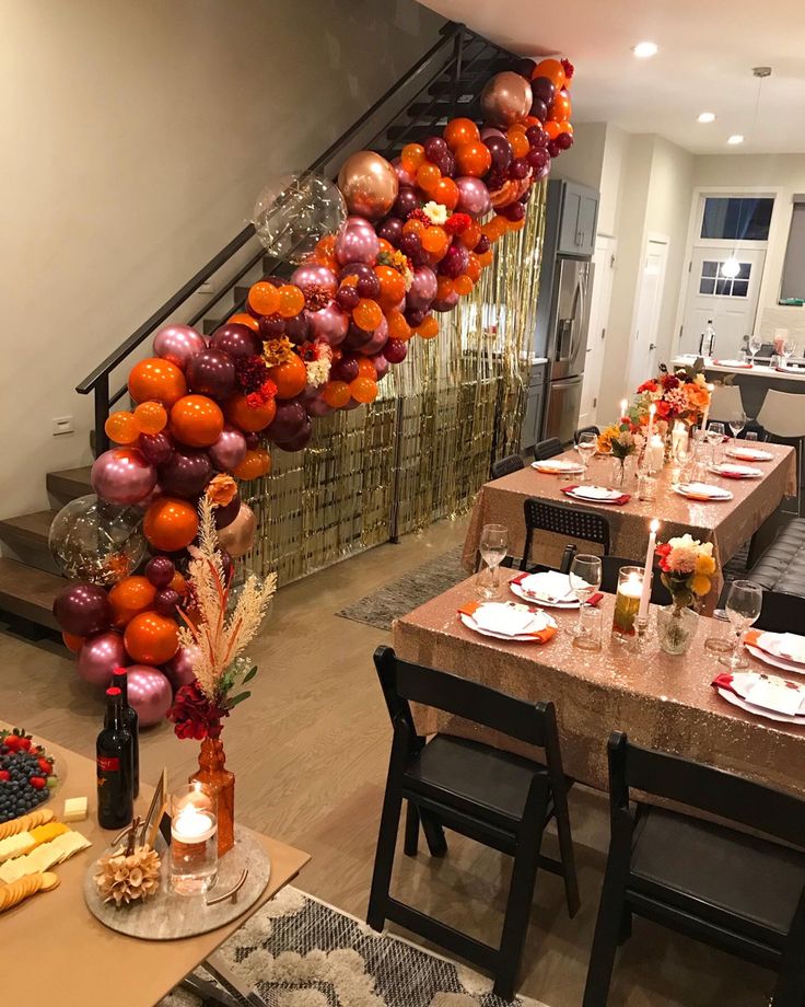 the table is set with many plates and place settings, along with balloons in the shape of a spiral