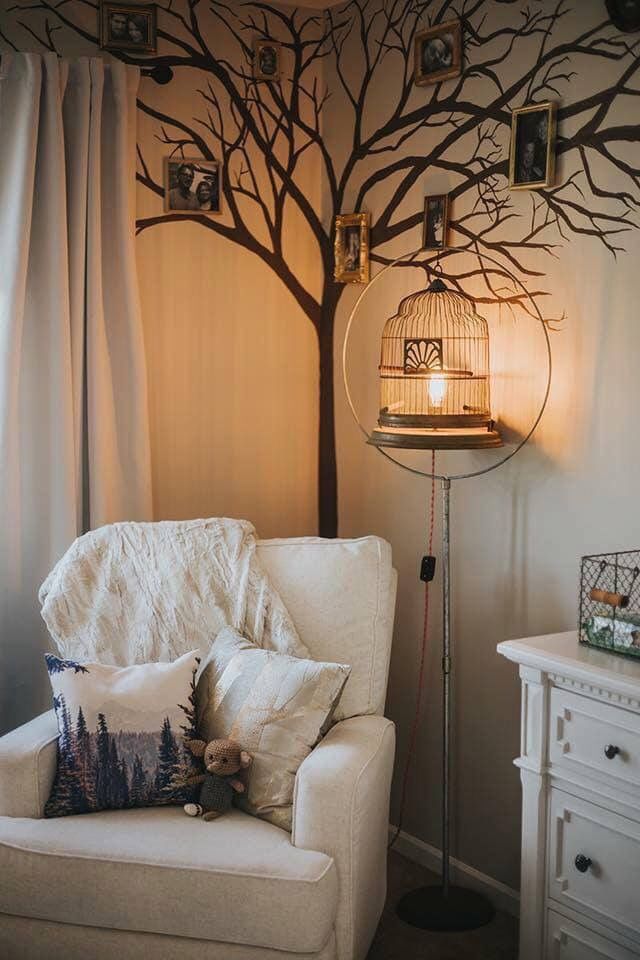 a living room with a birdcage on the wall and a tree behind it