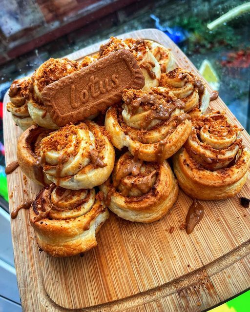 cinnamon rolls on a wooden cutting board with a chocolate bar