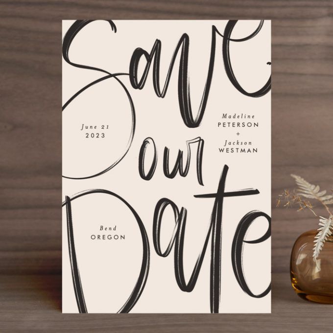 a card with the words save our date on it next to a vase filled with flowers