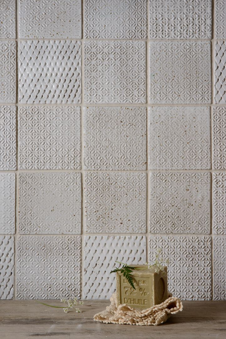 a small box sitting on top of a wooden table next to a white tiled wall