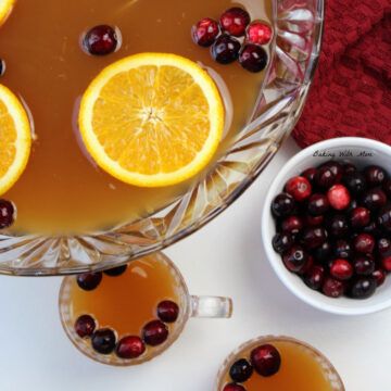 two glasses of tea with orange slices and cranberries