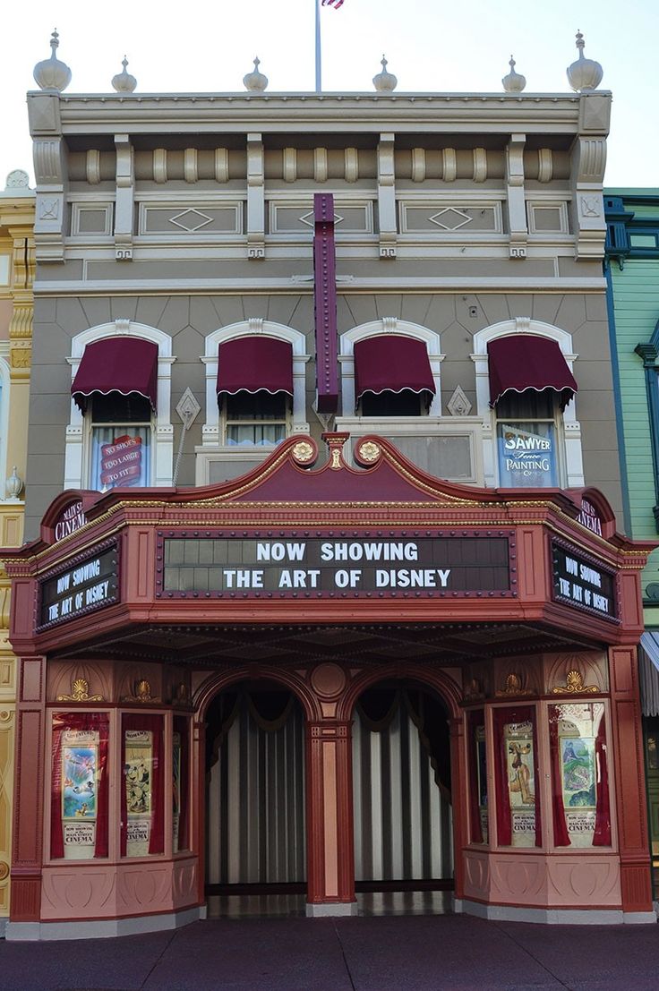 an old theater building with the words now showing the art of disney written on it