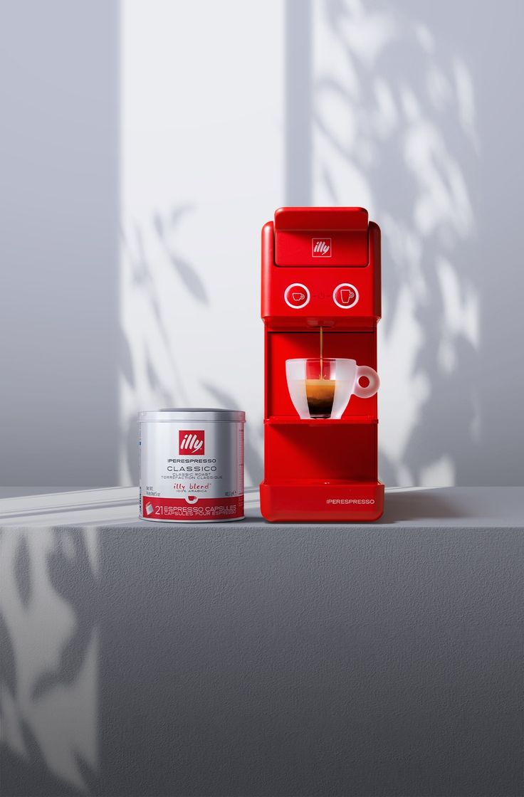 a red machine sitting next to a can of coffee