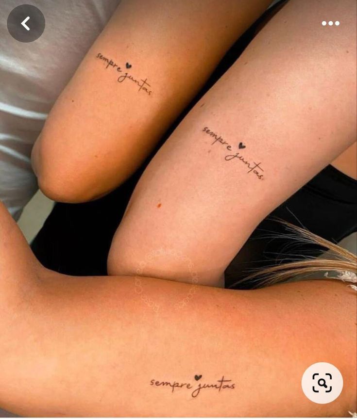 two girls with matching tattoos on their arms, one has the word love and the other is