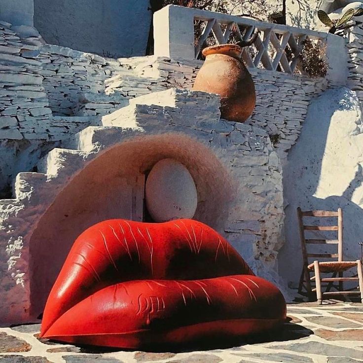 an outdoor area with red and white furniture, including a large sculpture in the shape of lips